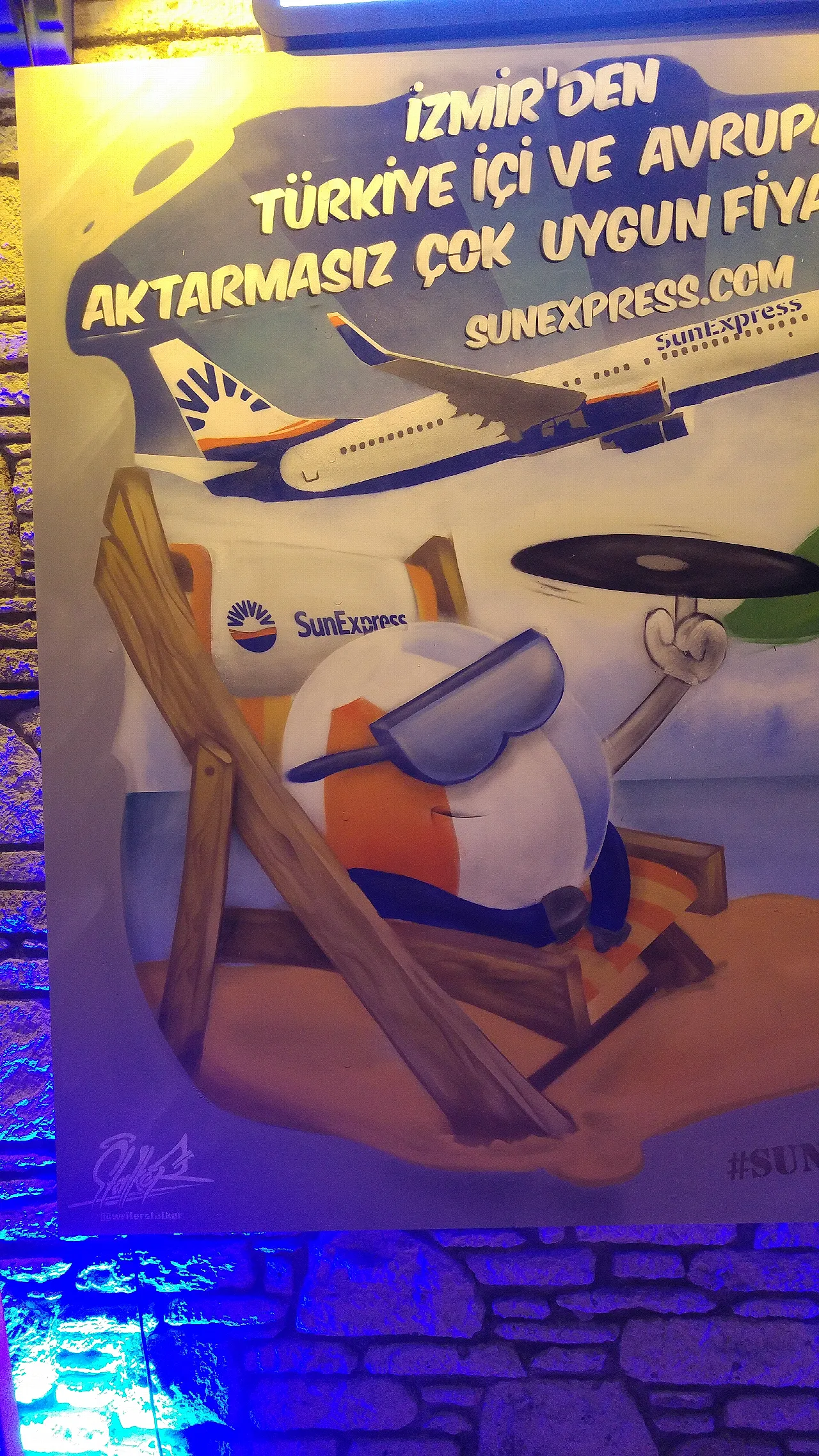 a spray-painted beach ball picture with sunbathing sunglasses